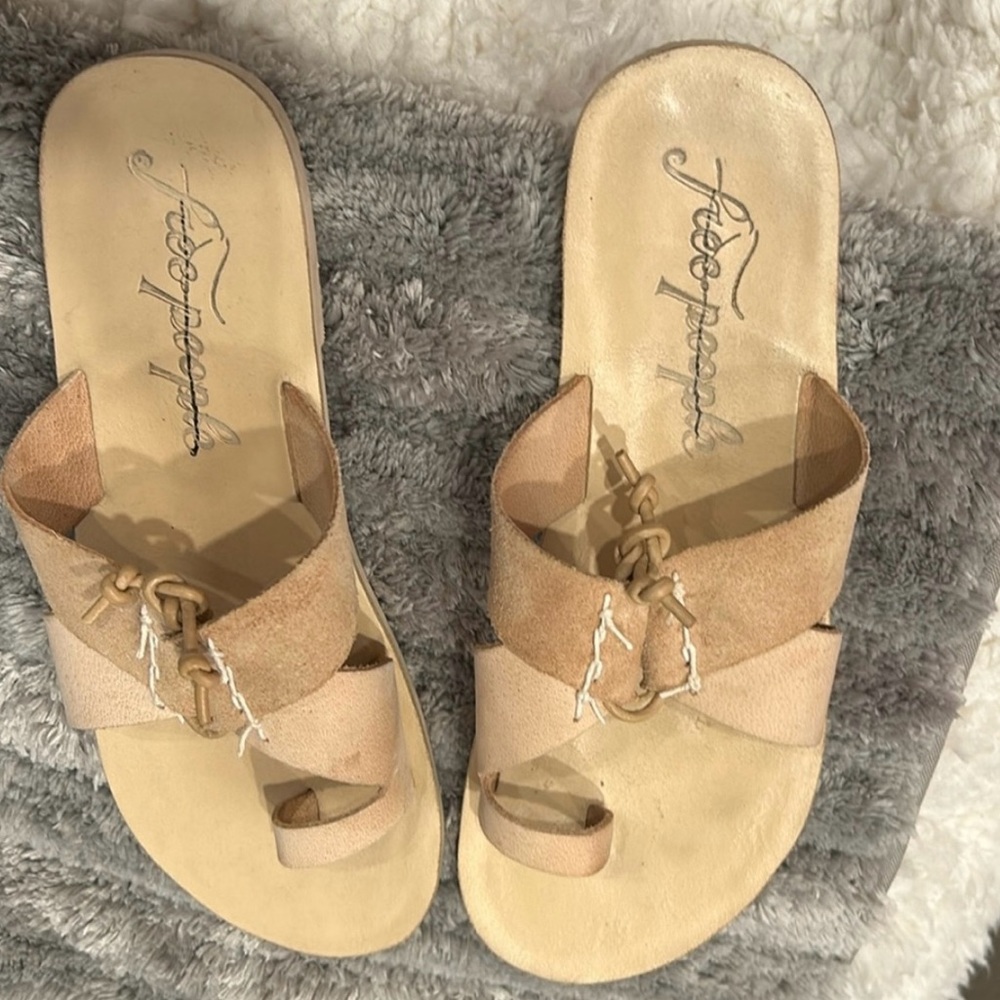 Leather light cream tan sandals with a tie that can be used to adjust width.